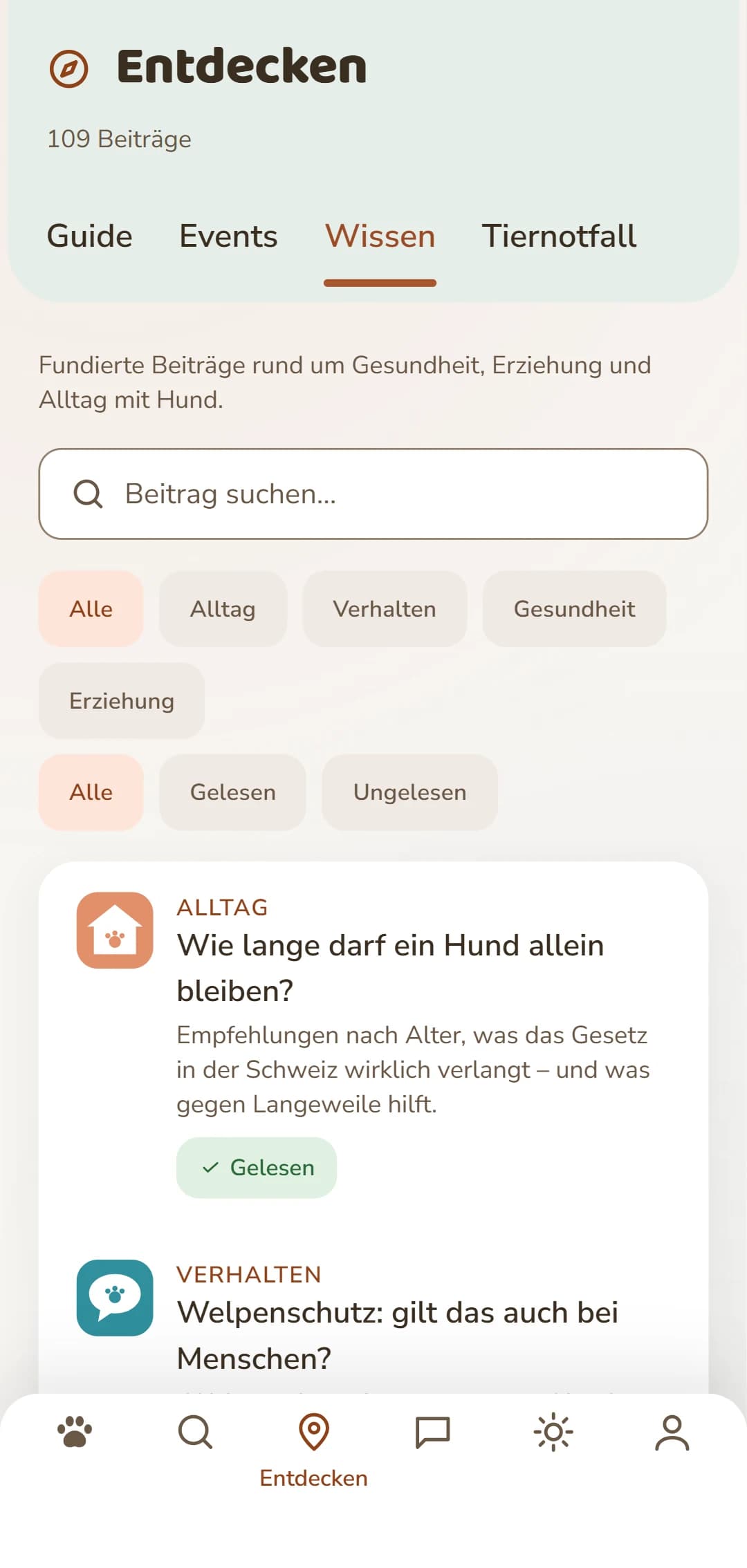 Bildschirmfoto der DOGSY-App im Reiter «Entdecken»: zuoberst die Zahl der Beiträge, darunter die vier Reiter Guide, Events, Wissen und Tiernotfall. Es folgen ein Suchfeld und runde Filter für die Rubriken – Alle, Alltag, Gesundheit, Verhalten, Erziehung. Darunter die Beiträge als Karten: links ein farbiges Rubrik-Symbol, daneben die Rubrik in Grossbuchstaben, der Titel und ein kurzer Anriss. Ganz unten die Navigationsleiste der App. Die Aufnahme erscheint in der Sprache dieser Seite.